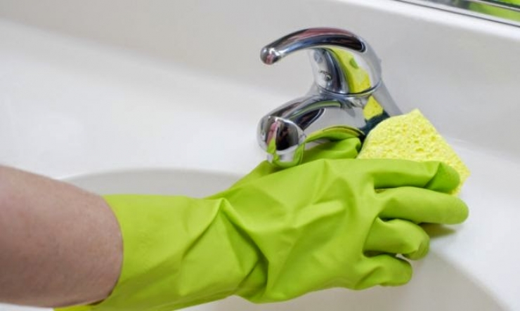 Una persona neteja un lavabo.