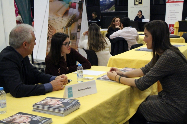 Una jove s'interessa per l'oferta laboral d'una perfumeria, al Fòrum Estudiants-Empresa.