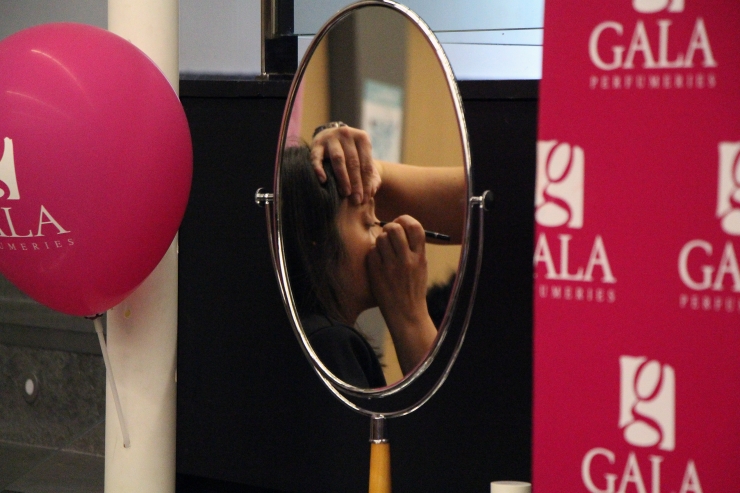 Una noia es maquilla a l'estand d'una perfumeria, al Fòrum Estudiants-Empresa.