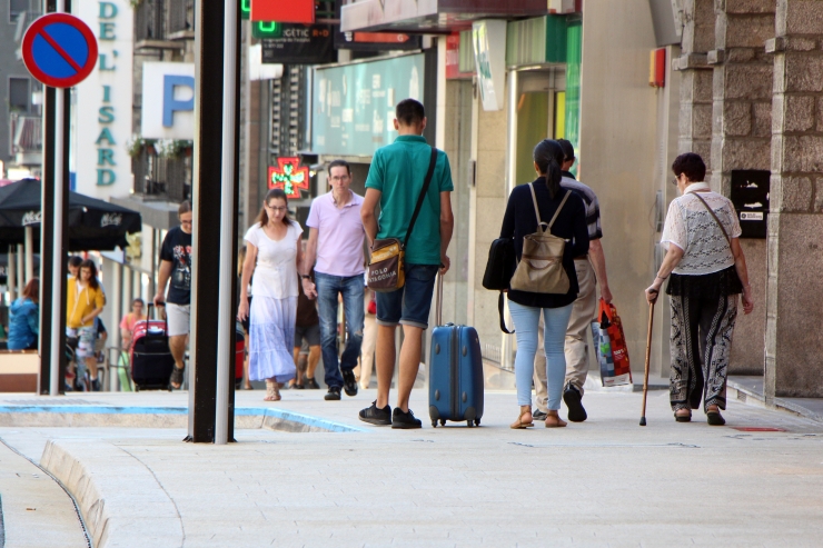 Turistes amb maletes caminant per l'avinguda Meritxell aquest mes d'agost.