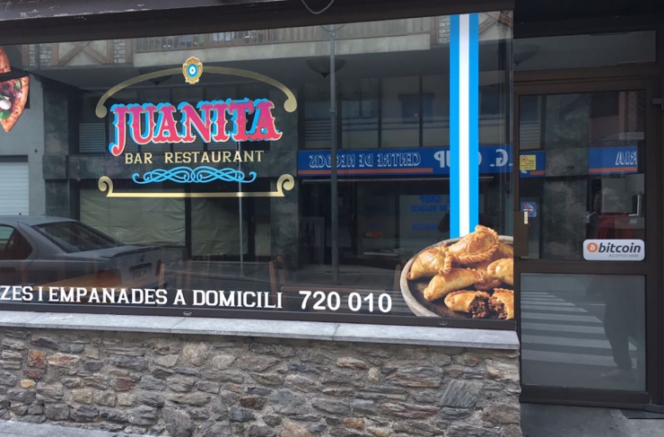 Façana del restaurant Juanita a Encamp amb el cartell, a la dreta, de l'acceptació del pagament amb bitcoins.