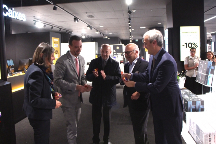 El ministre d'Ordenament Territorial, Jordi Torres, i les autoritats de la botiga un cop tallada la cinta.