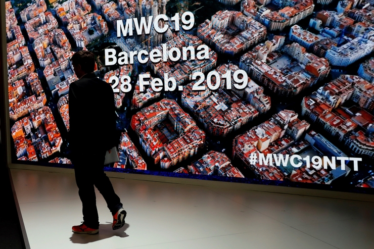 Un visitant passa per davant d'un panell a la darrera jornada del MWC.