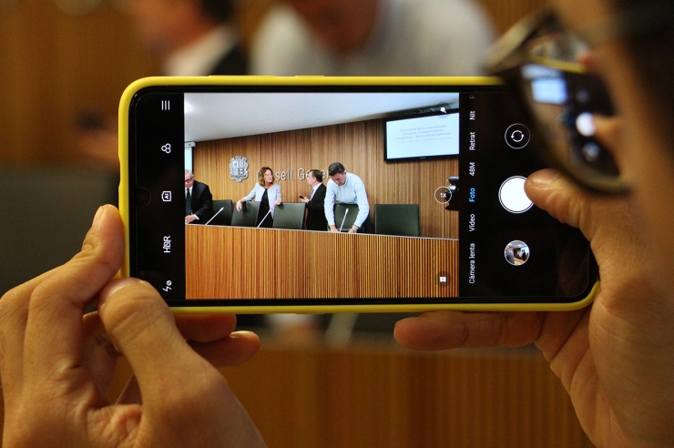 Un dels assistents fotografia la ministra de Medi Ambient, Sílvia Calvó, moments abans de l'inici de la comissió legislativa.
