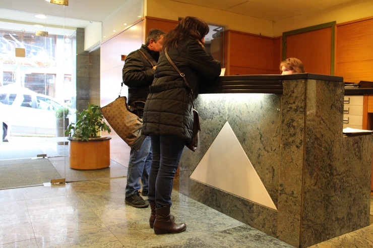 Dos turistes en una recepció d'un hotel.
 
