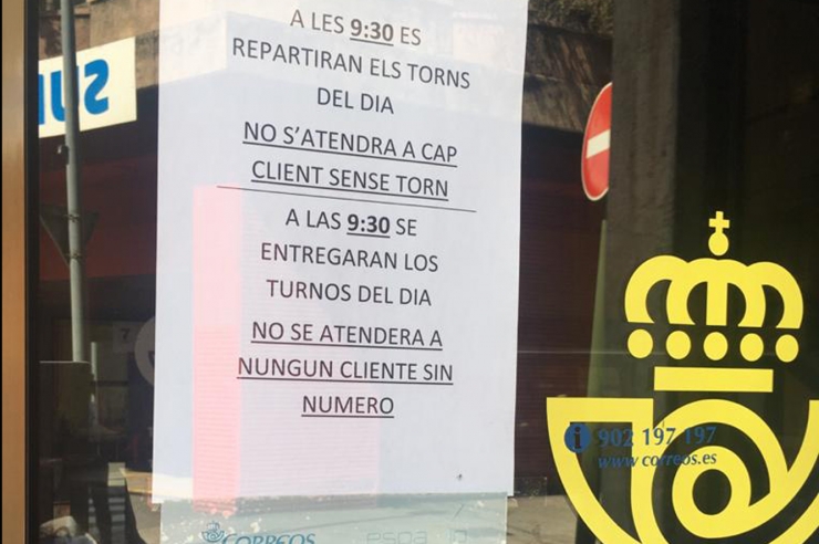 L'avís a la porta de Correus espanyols amb els nous horaris i mesures.