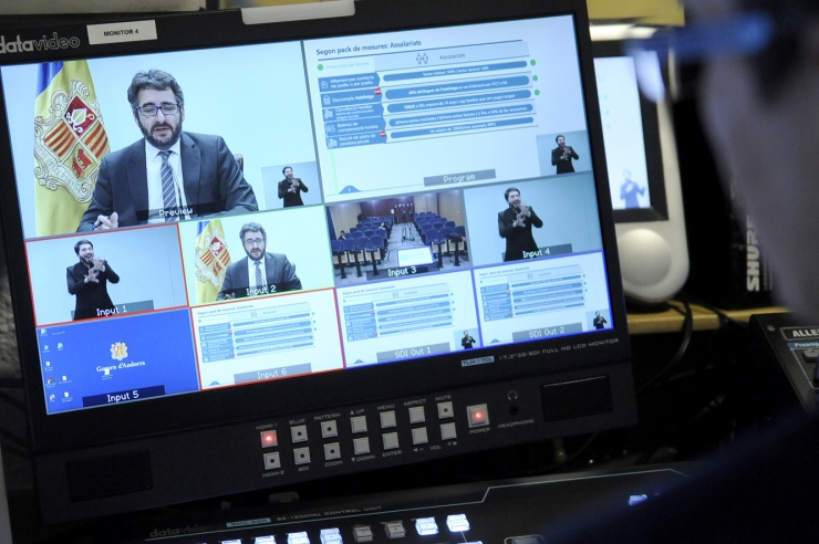 El ministre portaveu, Eric Jover, a través de les pantalles televisives de la sala de premsa del Govern.