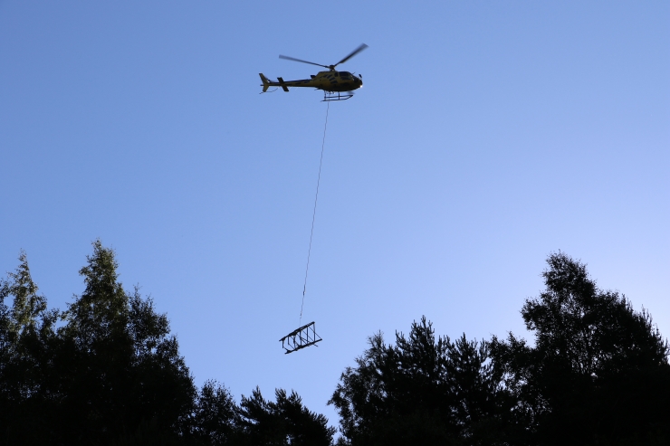 Amb un ganxo, l'helicòpter agafa parts de les torres de mitja tensió en desús.