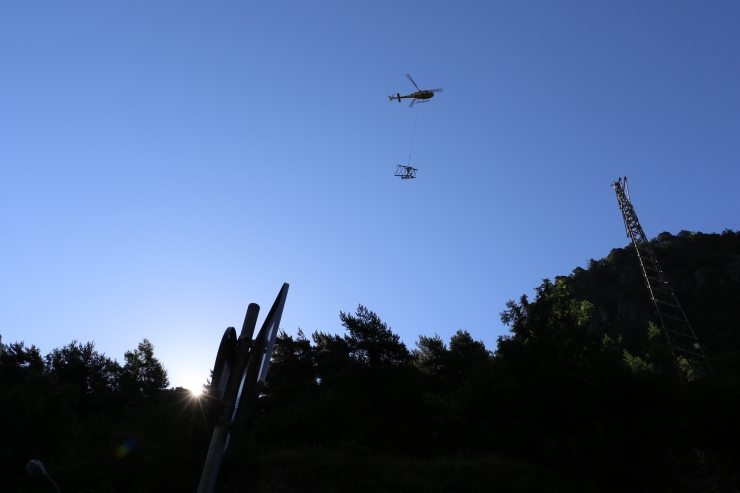 Pla general de l'helicòpter retirant una de les torres de mitja tensió.