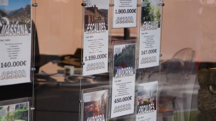 Aparador d'una immobiliària amb l'anunci de diversos pisos de compra.