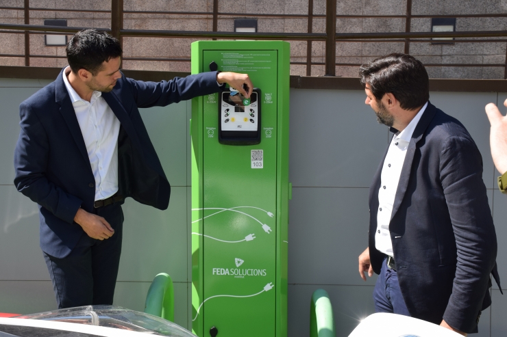 El gerent de FEDA Solucions, Ivan Mora, i el product manager d'Electromaps, Luís Martín, fan una mostra de l'aplicació i del clauer al punt de càrrega de FEDA.