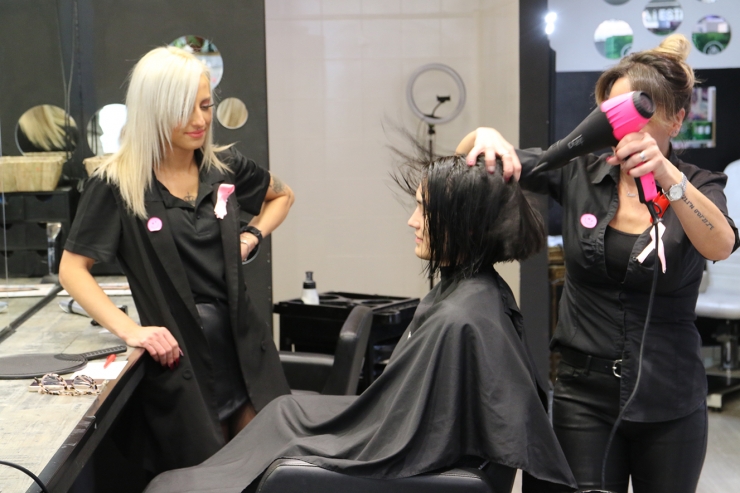 Una perruquera de Kerala perruqueria i estètica assecant els cabells a una clienta.
