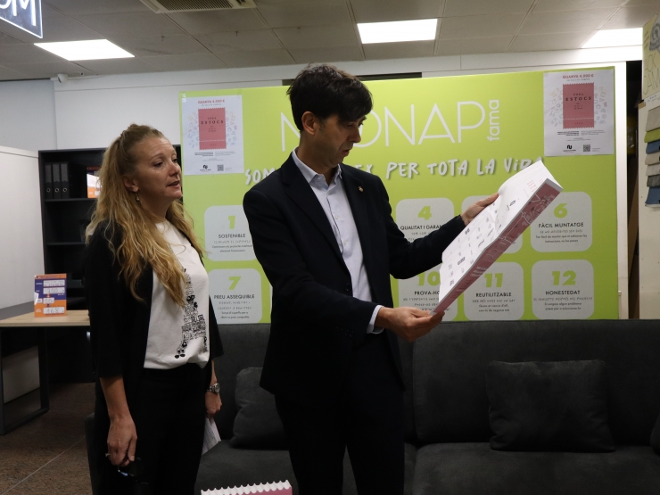 El cònsol major d'Andorra la Vella, Sergi González i la delegada de  desenvolupament i assessorament comercial i empresarial del comú  d'Andorra la Vella, Susagna Venable, consulten el fulletó que s'ha editat per a la cita comercial.