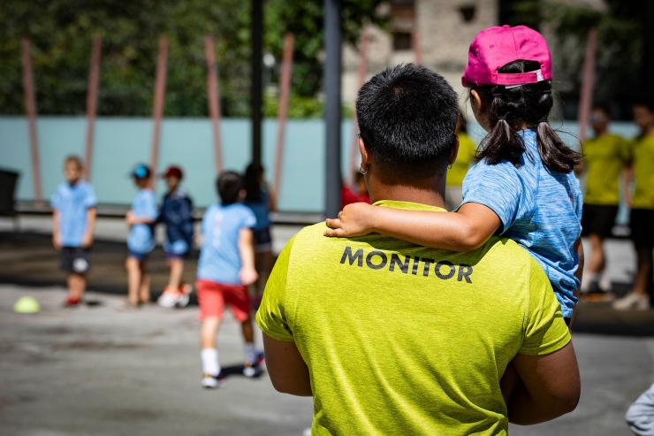 Un monitor i un grup de nens i nenes fent una activitat de lleure.