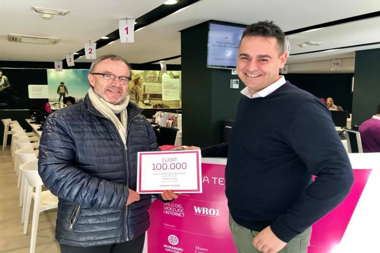 Josep Maria Morató, el client 100.000, rep un targetó de mans del responsable de l'agència, Jonatan Fontán.