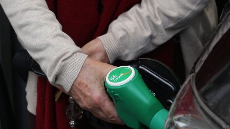 Una persona posa carburant al seu vehicle.