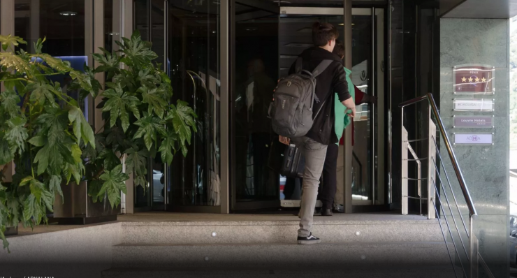 Un turista a l'entrada d'un hotel.