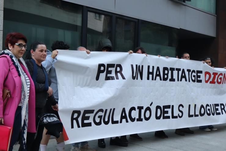 La portaveu del Sindicat de l'Habitatge, Rebeca Bonache, i altres membres del col·lectiu amb una pancarta després de la reunió amb la ministra d'Habitatge, Conxita Marsol.