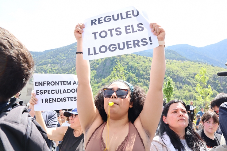 Una dona sosté una pancarta durant la protesta a la plaça del Poble.
 